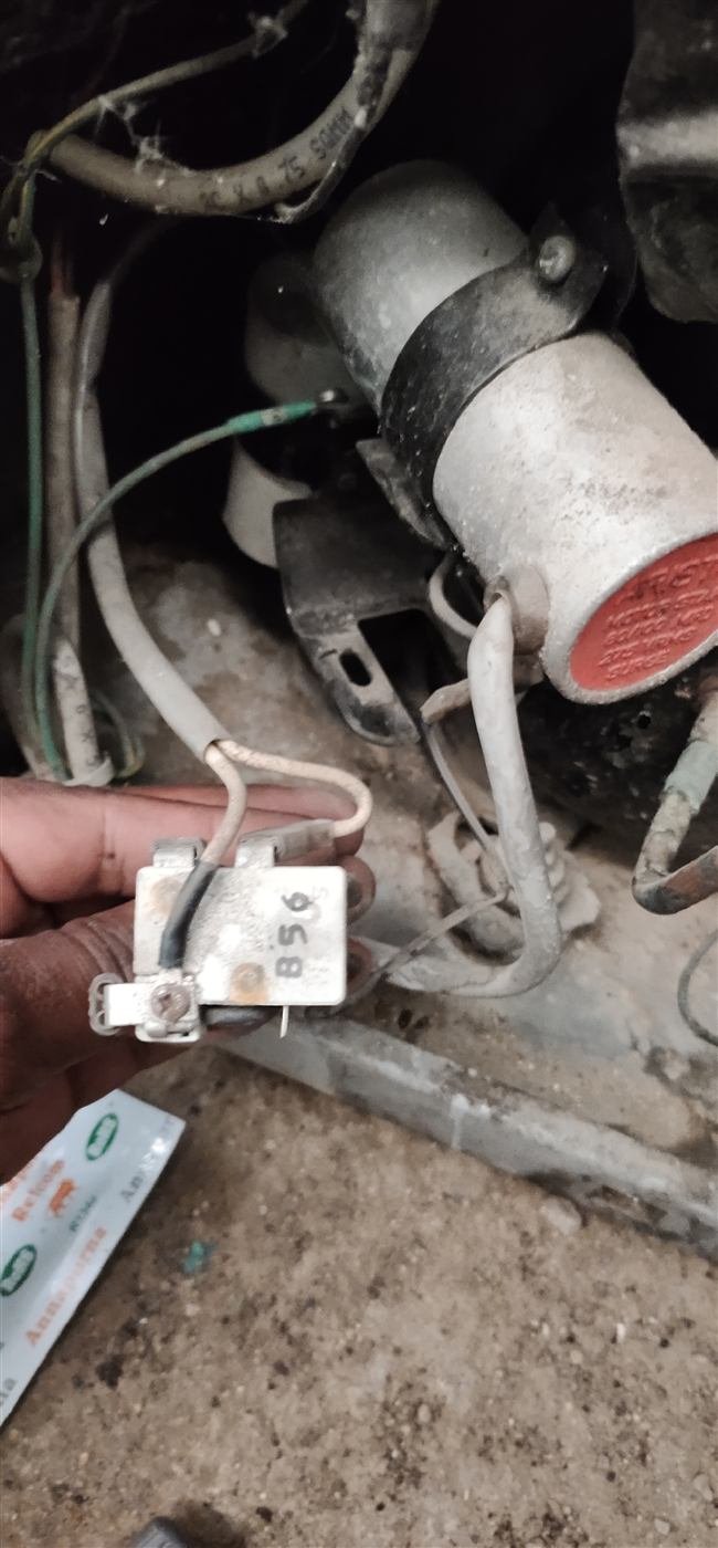 AN Repair Services technician holding a refrigerator compressor relay component during a repair
