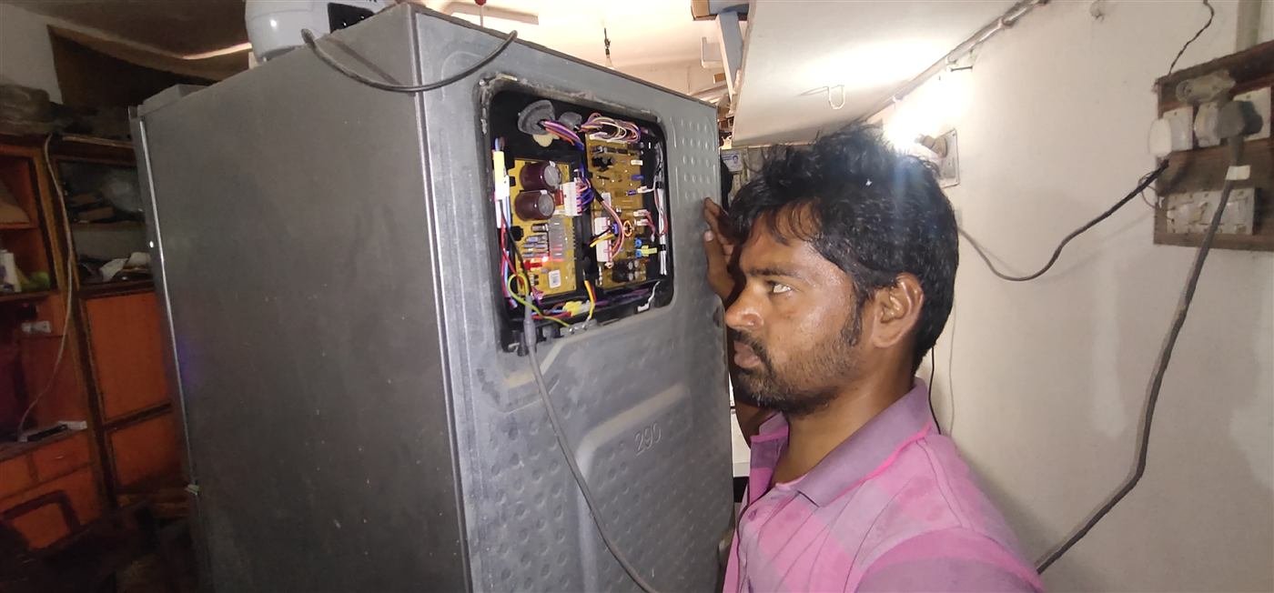 AN Repair Services technician diagnosing a refrigerator circuit board in Kamareddy
